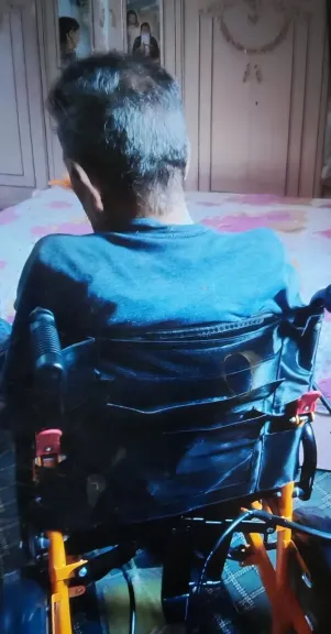 المواطن يتسلم الكرسي المتحرك